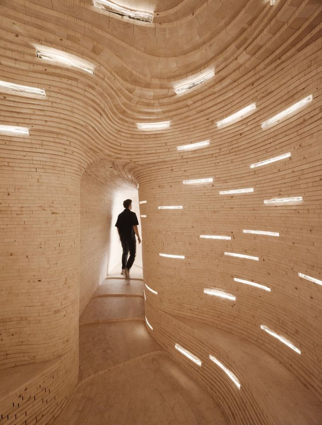 A vaulted passage pierced with points of daylight, a figure at the far end